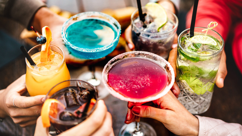 Toasting with assorted colorful cocktails