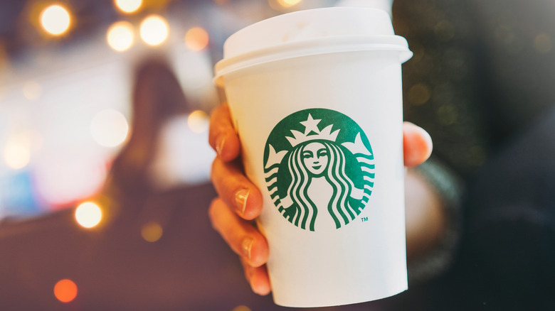 Person holding a Starbucks coffee cup