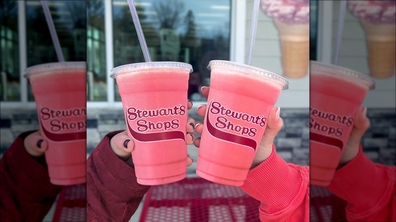 Two people holding pink iced fruit drinks from Stewart's Shops