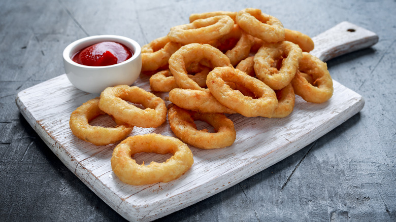 onion rings and ketchup on board