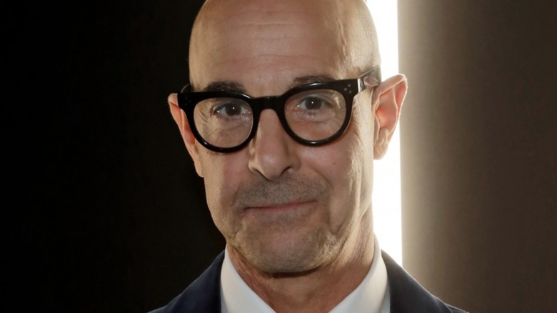 Stanley Tucci smiles with glasses in close up