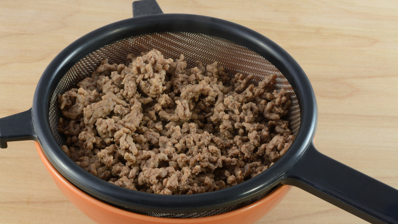 Ground beef in a strainer