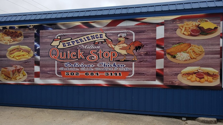 Sign for Milton Quick Stop chicken on side of blue building
