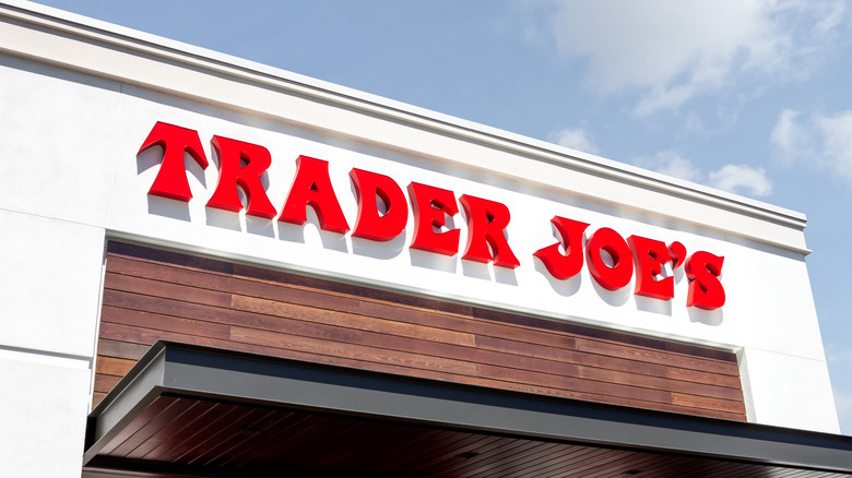 Red Trader Joe's logo on white building against blue sky