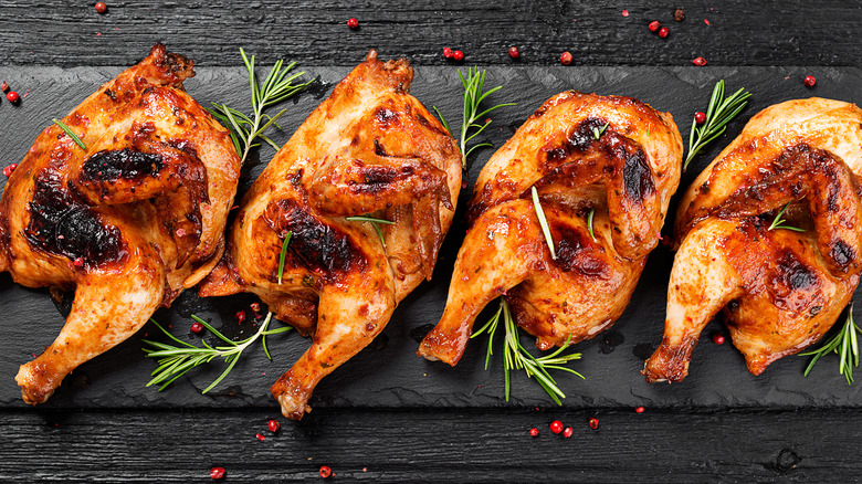 Chicken with crispy brown skin and rosemary garnish