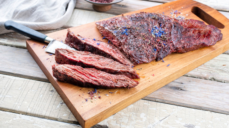 Cooked and sliced bavette steak on cutting board
