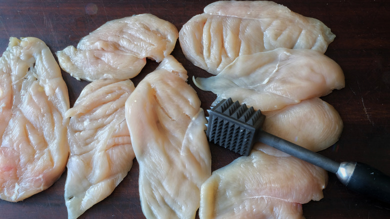 Flattened chicken breasts and a meat tenderizer 