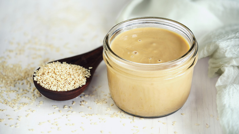 Glass jar of tahini with sesame seeds