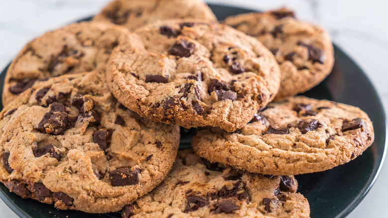 Pile of chocolate chip cookies on black plate