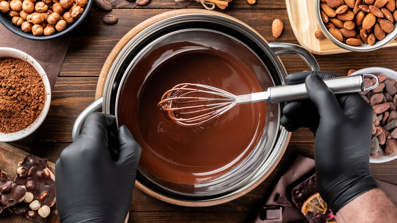 Confectioner stirring melted chocolate in bowl