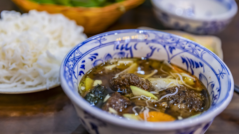 Bowl of Bún Chả on table with other dishes