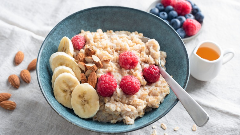 Bowl of oatmeal topped with fruit and almonds
