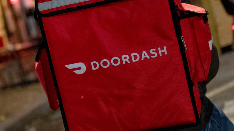 DoorDash delivery driver with takeout bag