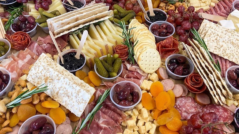 A full charcuterie board of meat and fruit