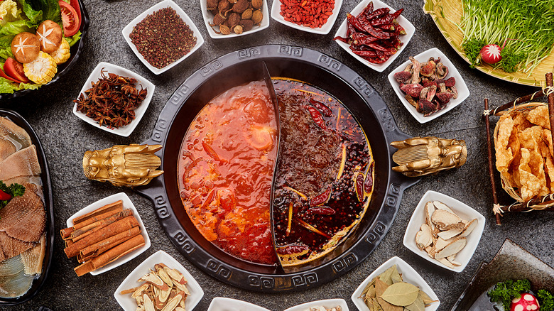 Chinese hot pot surrounded by ingredients 