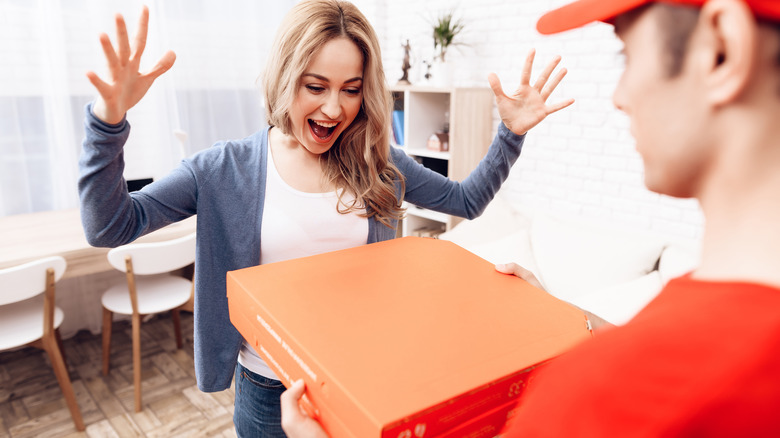 A pizza delivery man making a delivery