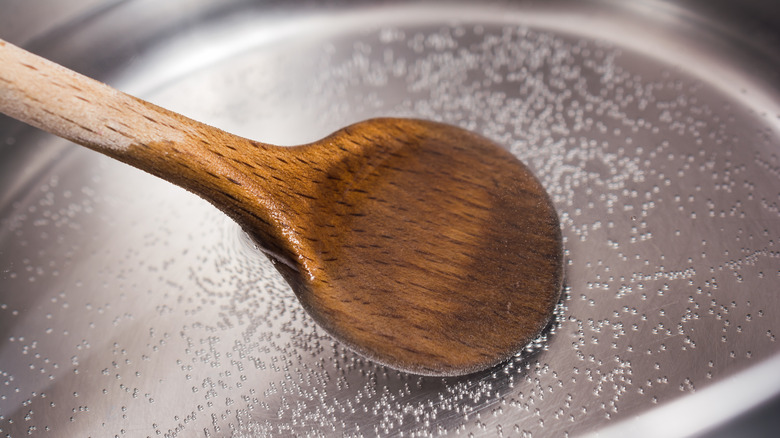 placing a wooden spoon in simmering water