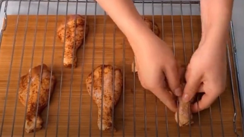 TikTok user sticking drumsticks through rack