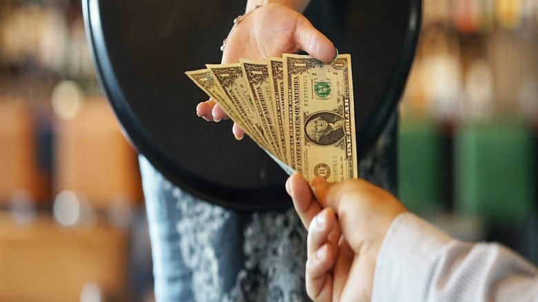 Person handing cash to restaurant server