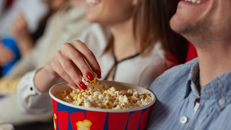 Couple enjoying popcorn at theater