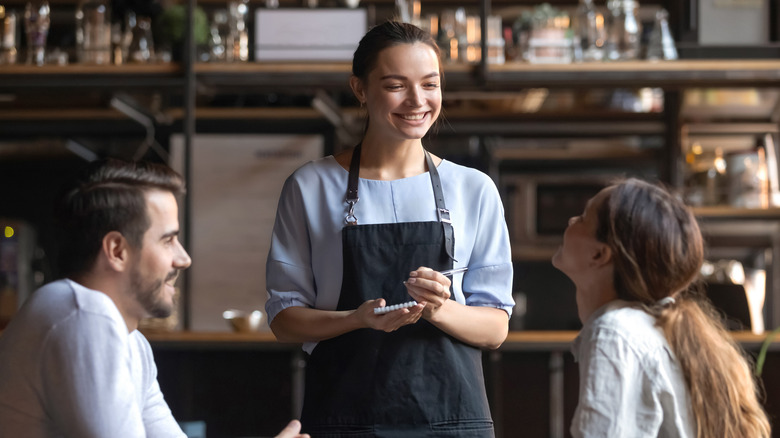 Restaurant waitress taking order from guests