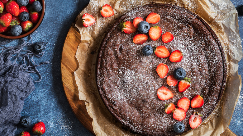 Round chocolate cake topped with berries