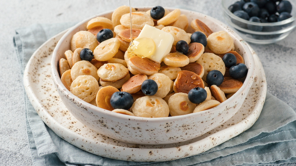 Pancake cereal with honey, butter, and blueberries