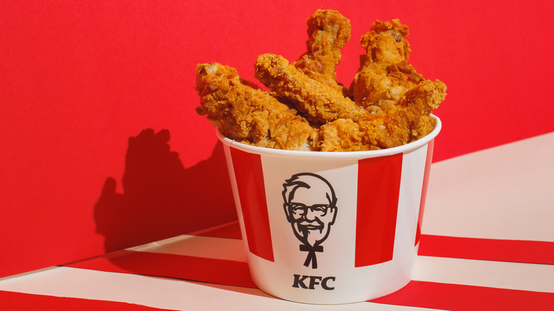Bucket of KFC chicken against a red background