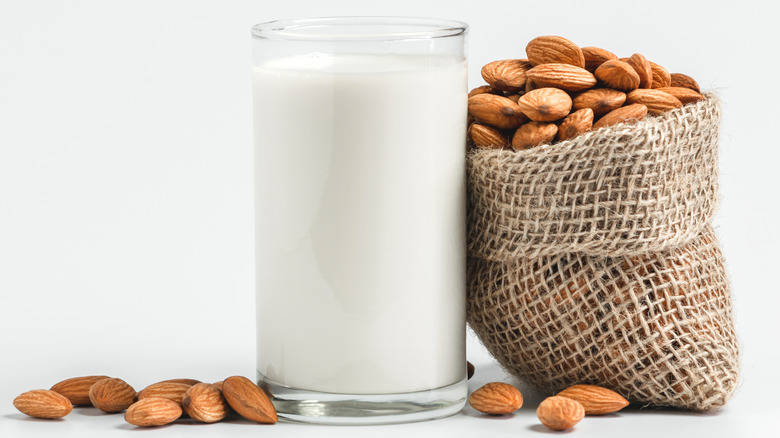 A glass of milk next to almonds