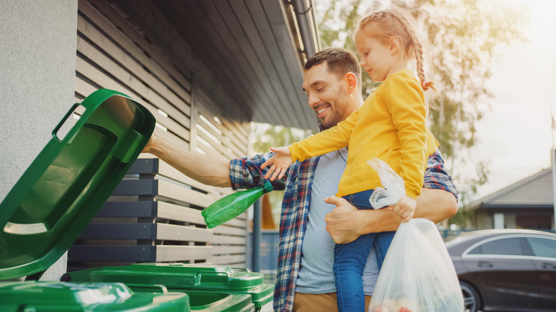 Dad and daughter throwing away garbage