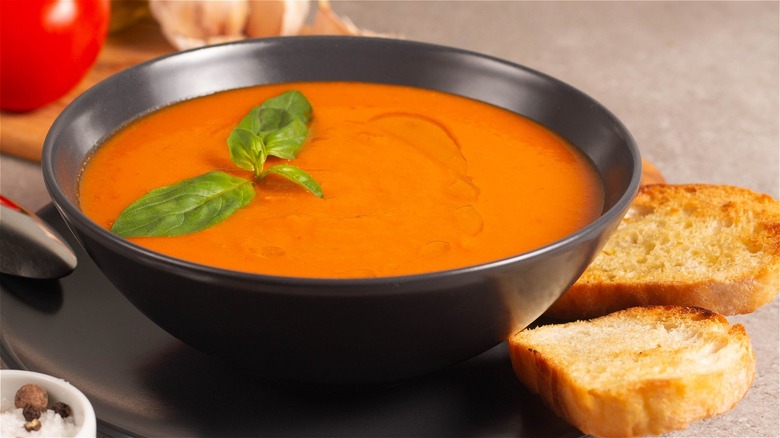 bowl of tomato soup with slices of bread