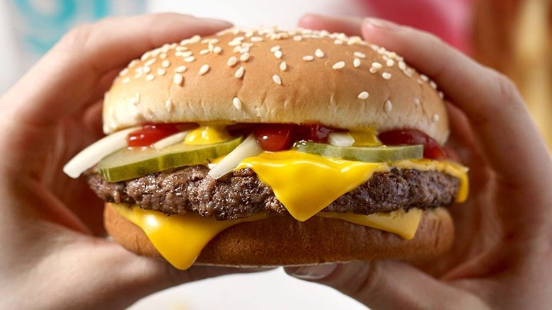 Person holding a McDonald's hamburger