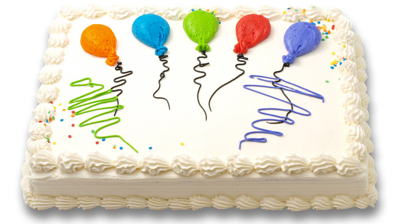 White sheet cake with colorful balloon decorations