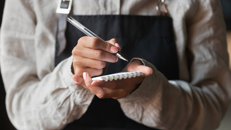 waitress writing order on notepad