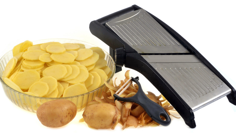 Sliced potatoes and utensils