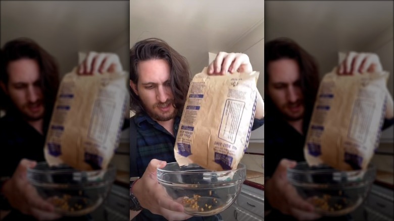 Man shaking kernels out of microwave popcorn