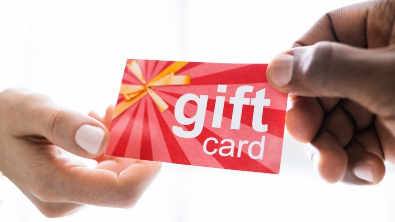 Two hands holding a gift card