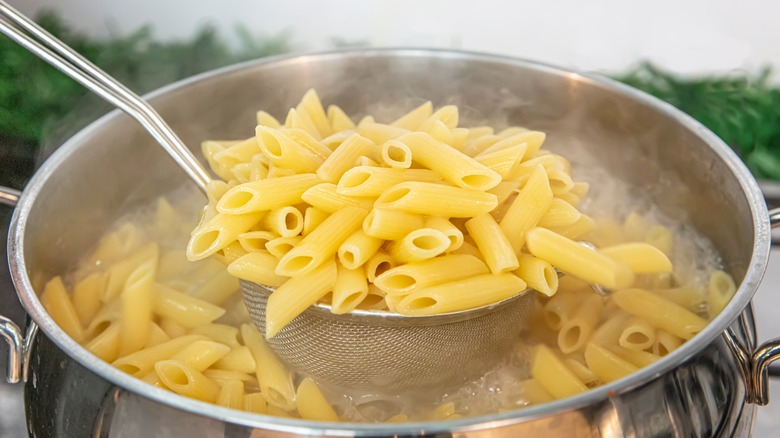 ladeling penne pasta noodles