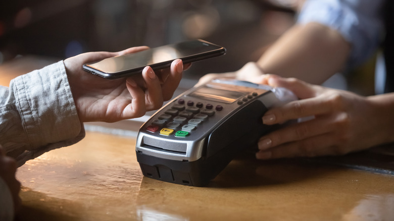 A person paying a bill with their smartphone