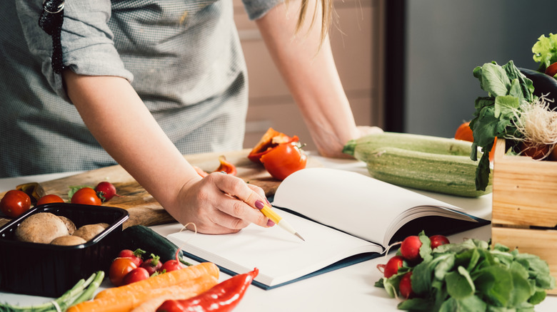 woman reading recipe in cookbook