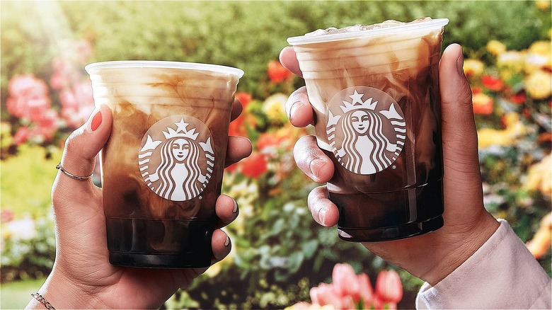 two people holding starbucks iced coffee