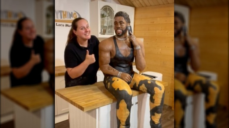 TikTok user posing with a life-size Jason Derulo cake.