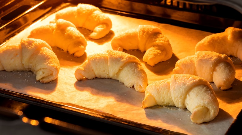 Croissants baking on a tray in an oven