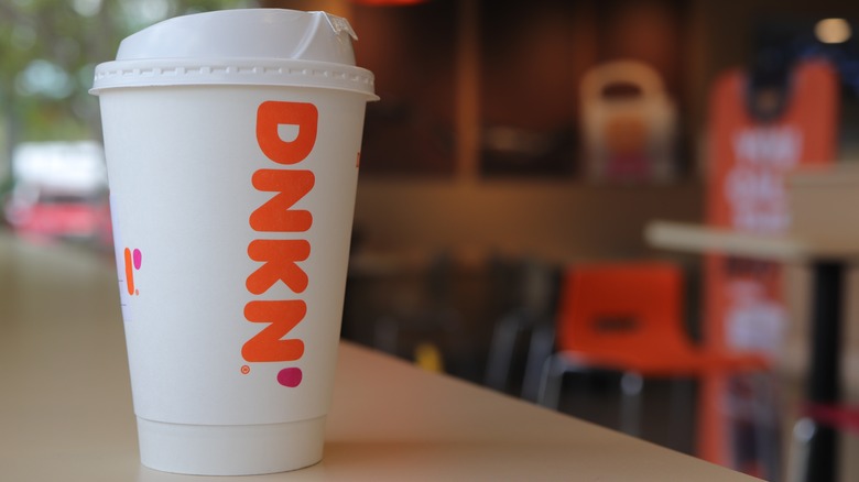 A cup of Dunkin' coffee sitting on a table
