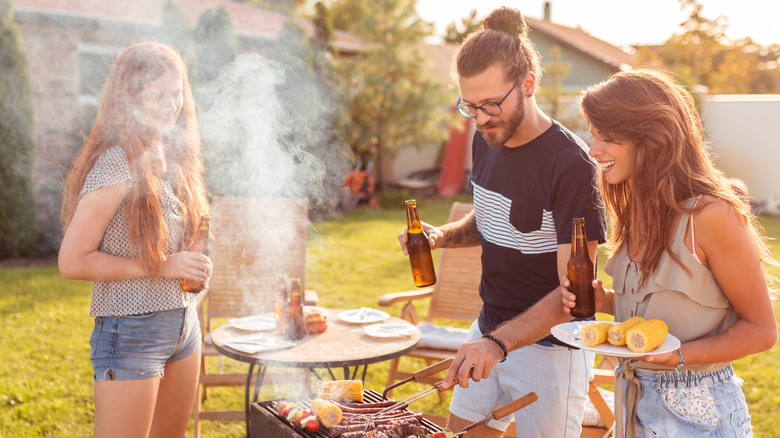 people around grill with beers