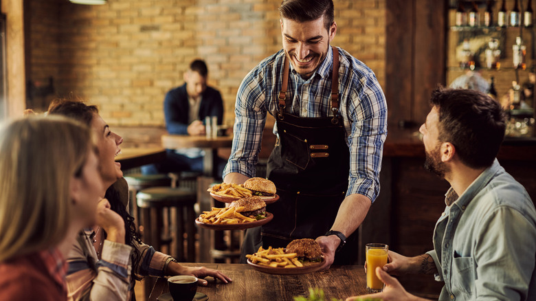 Waiter serving food in restaurant