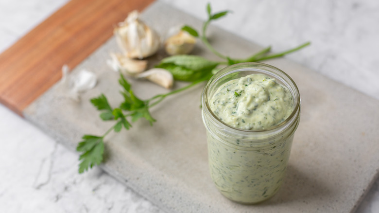 Green goddess dressing in jar on marble table