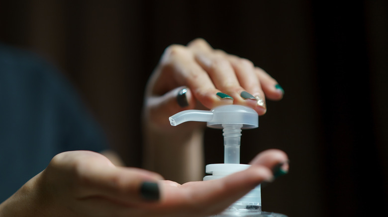 A person using a hand soap pump