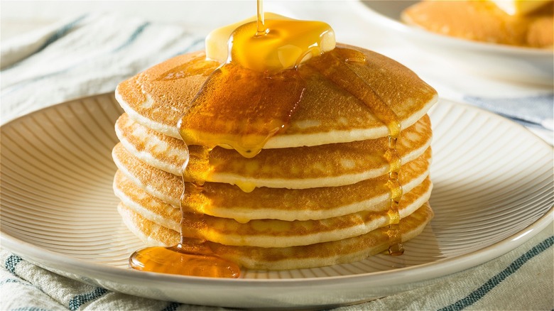 A stack of pancakes with butter and syrup
