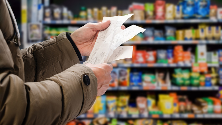 a person looking at receipts in a grocery store